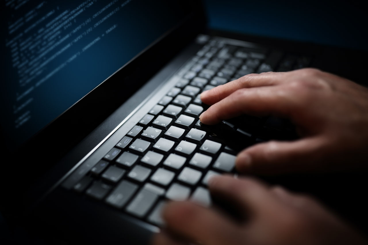 Programmer typing on laptop keyboard