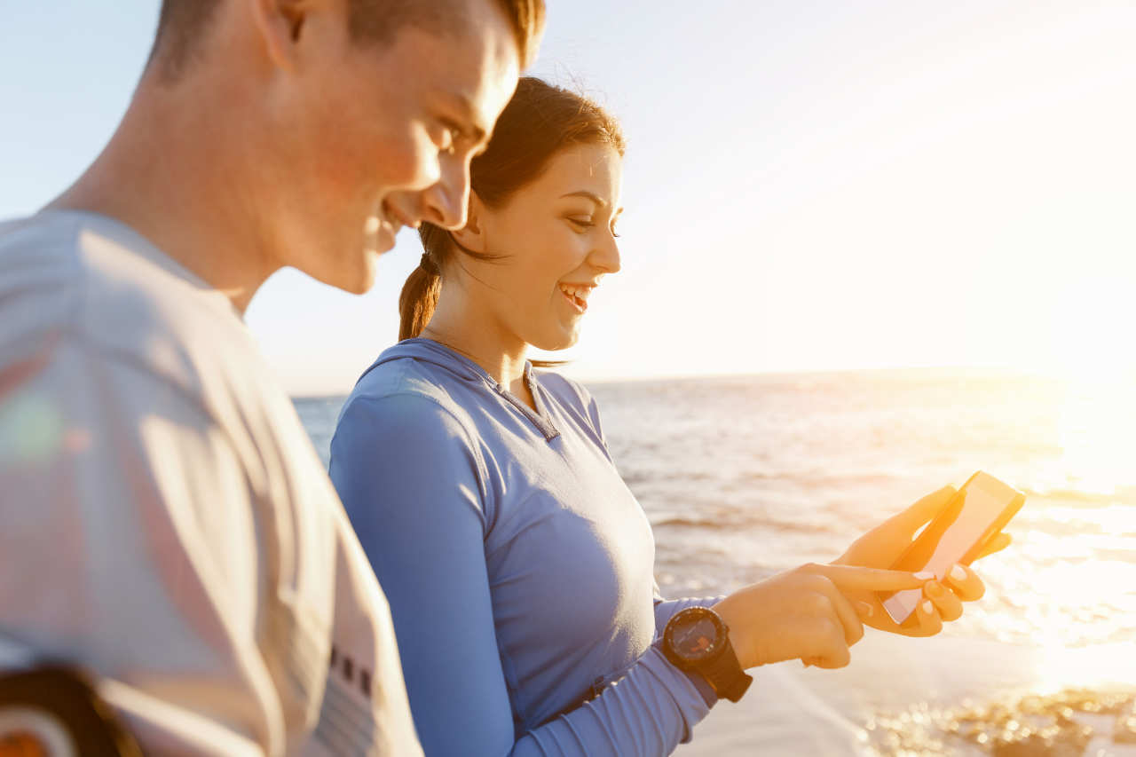 Young couple with smartphones outdoors