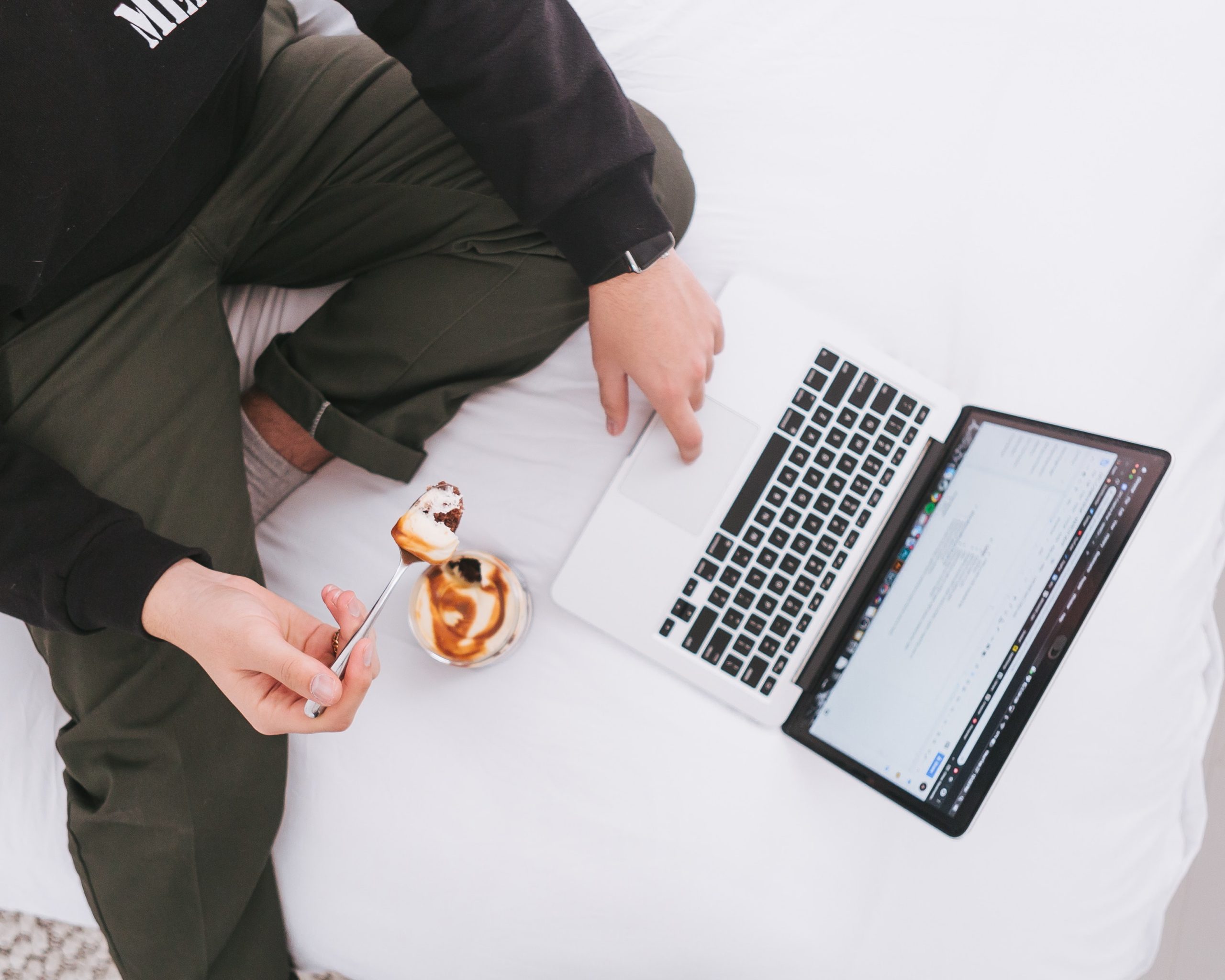 man working while eating cake in a cup